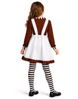 Person wearing a brown and white dress with suspenders on a white background