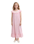 Young girl wearing a pink nightgown with floral embroidery on a white background
