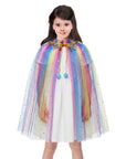Young girl wearing a colorful rainbow cape over a white dress on a white background