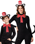 A woman and a boy wearing matching black cat costumes with red bow ties, black cat ears, and red-and-white striped hats against a plain white background.