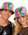 A man and a woman wearing shiny rainbow holographic bucket hats, posing against a solid white background.