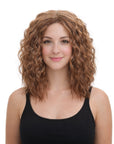 Woman with curly brown hair wearing a black tank top on a white background