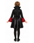 A child model shown from the back wearing a black vampire costume dress with red patterned cuffs, black tights, and black shoes against a plain white background.