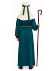 A child shown from the back wearing a long teal robe with a cream neck drape tied with a teal ribbon, holding a brown shepherd's staff against a plain white background.