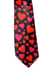 A black necktie with a repeating pattern of red and pink hearts of various sizes, shown against a plain white background.