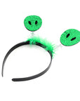 A novelty costume headband featuring a black plastic band, bright green feather trim, and two dangling green alien face discs on silver springs.