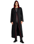 A man modeling a long black hooded robe with red lining, worn over a gray shirt and dark pants, against a plain white studio background.