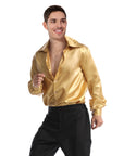 A man wearing a shiny metallic gold long-sleeve button-up shirt and black pants, posing against a solid white background.