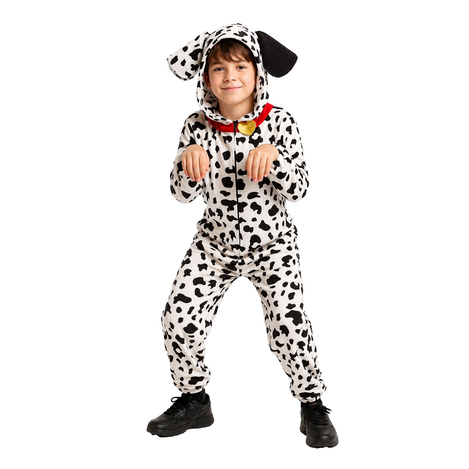 A child modeling a Dalmatian dog costume jumpsuit with black-and-white spotted pattern, floppy dog ears on the hood, and a red collar with a gold bell, photographed against a plain white background.