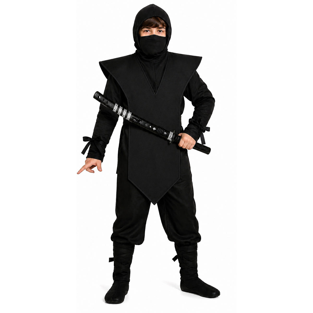 A child modeling a black ninja costume with a hooded mask, a large shoulder cape, loose pants, and black boots, holding a toy sword against a plain white background.