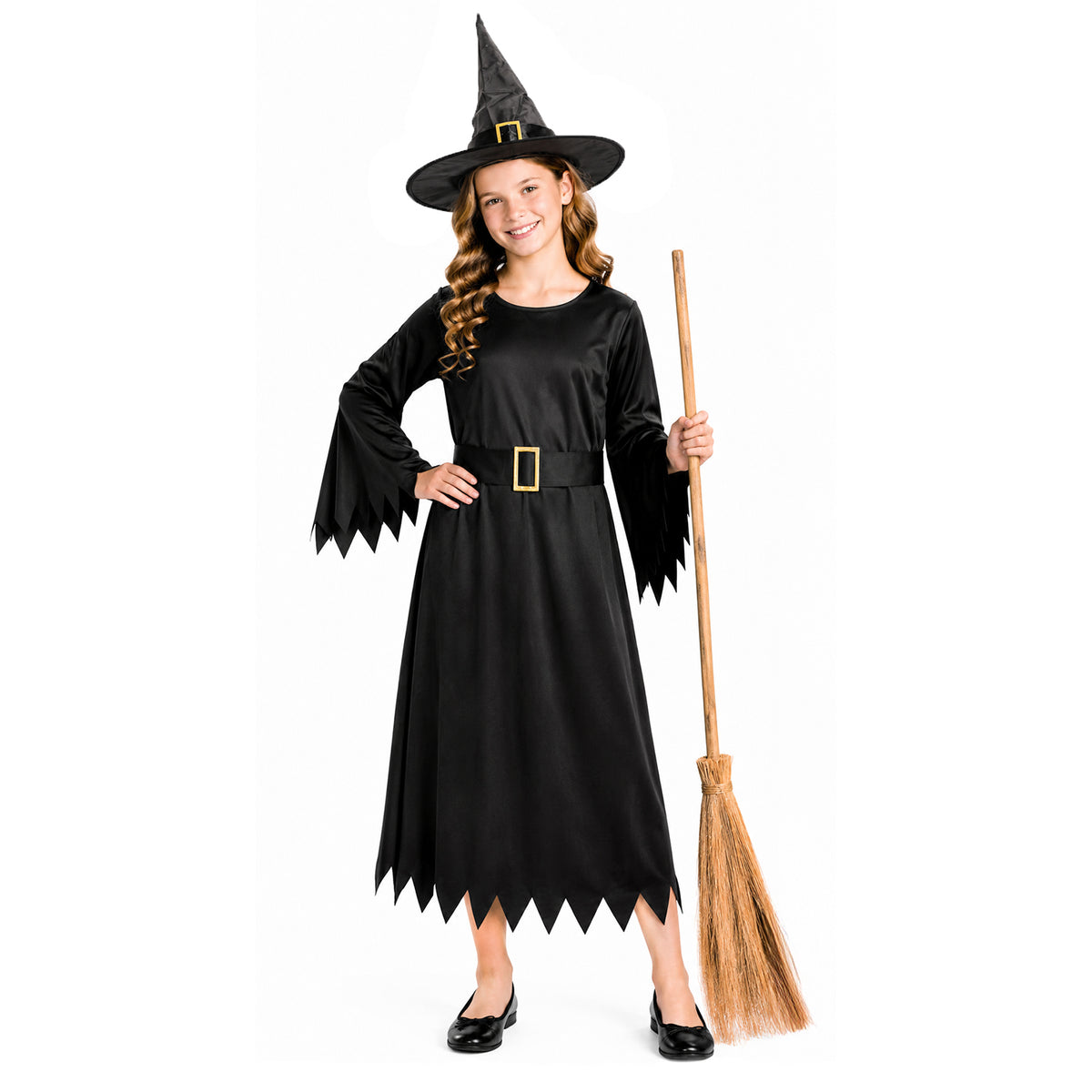 A young girl modeling a black witch costume dress with a pointed hat and holding a broomstick against a plain white background.
