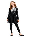 girl modelling a black skeleton dress costume on a white background.
