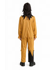 A child shown from the back wearing a costume jumpsuit in mustard yellow with black jagged trim, a black hood with spiky details, and black shoes, photographed on a plain white background.