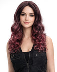 Woman with long, wavy, purple hair wearing a black sleeveless top on a white background