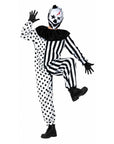 A person modeling a black and white clown costume with a polka-dot one-piece, black-and-white striped long-sleeve top, black ruffled collar, black gloves, black boots, and a white mask with black and red details, posed against a plain white background.