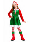 A young girl modeling a shiny green elf costume dress with red long sleeves, a red and white striped chest detail, a matching red and white Santa hat, red and white striped tights, and red elf boots with green panels, against a plain white background.