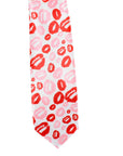 A white necktie featuring a playful pattern of red and pink lipstick kiss marks, isolated on a white background.