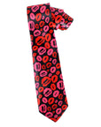A necktie with a bold pattern of pink and red lipstick kiss marks on a black background, shown against a plain white studio backdrop.